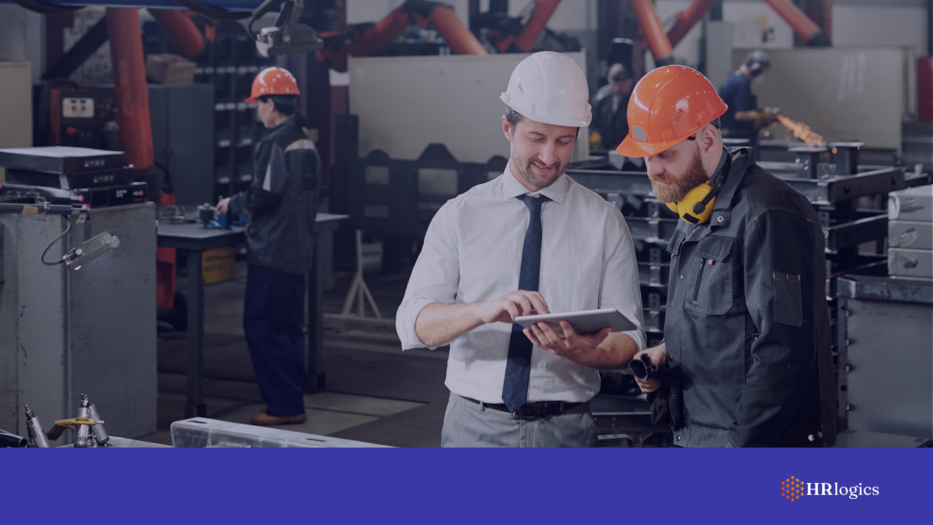 A production manager reviewing hiring documents with an employee in a factory setting